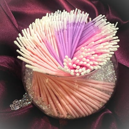 Colorful microswabs in a decorative container on a fabric background
