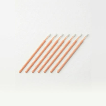 Set of peach colored microswabs on a white background