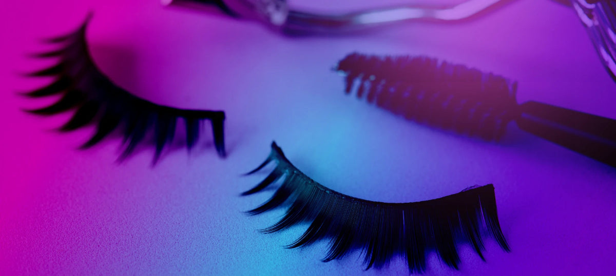 False eyelashes with a mascara wand on a purple background
