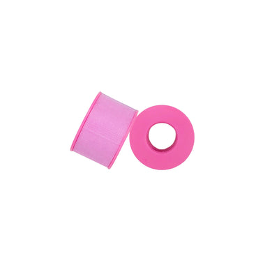 Pink hypoallergenic lash tape roll on white background — 1/2 inch x 9m, gentle adhesive for lash and brow services
